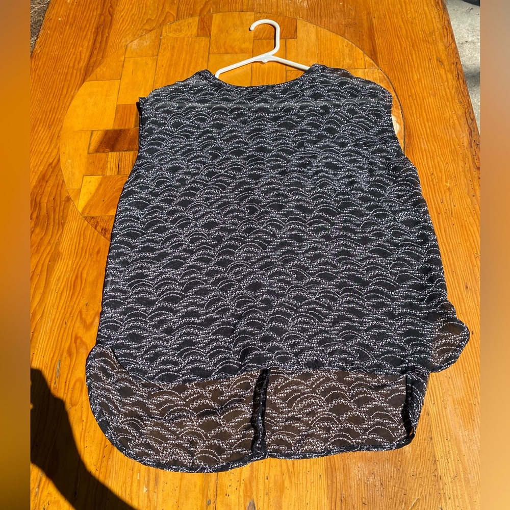 Sleeveless black top, semi sheer, with small skull and crossbones design